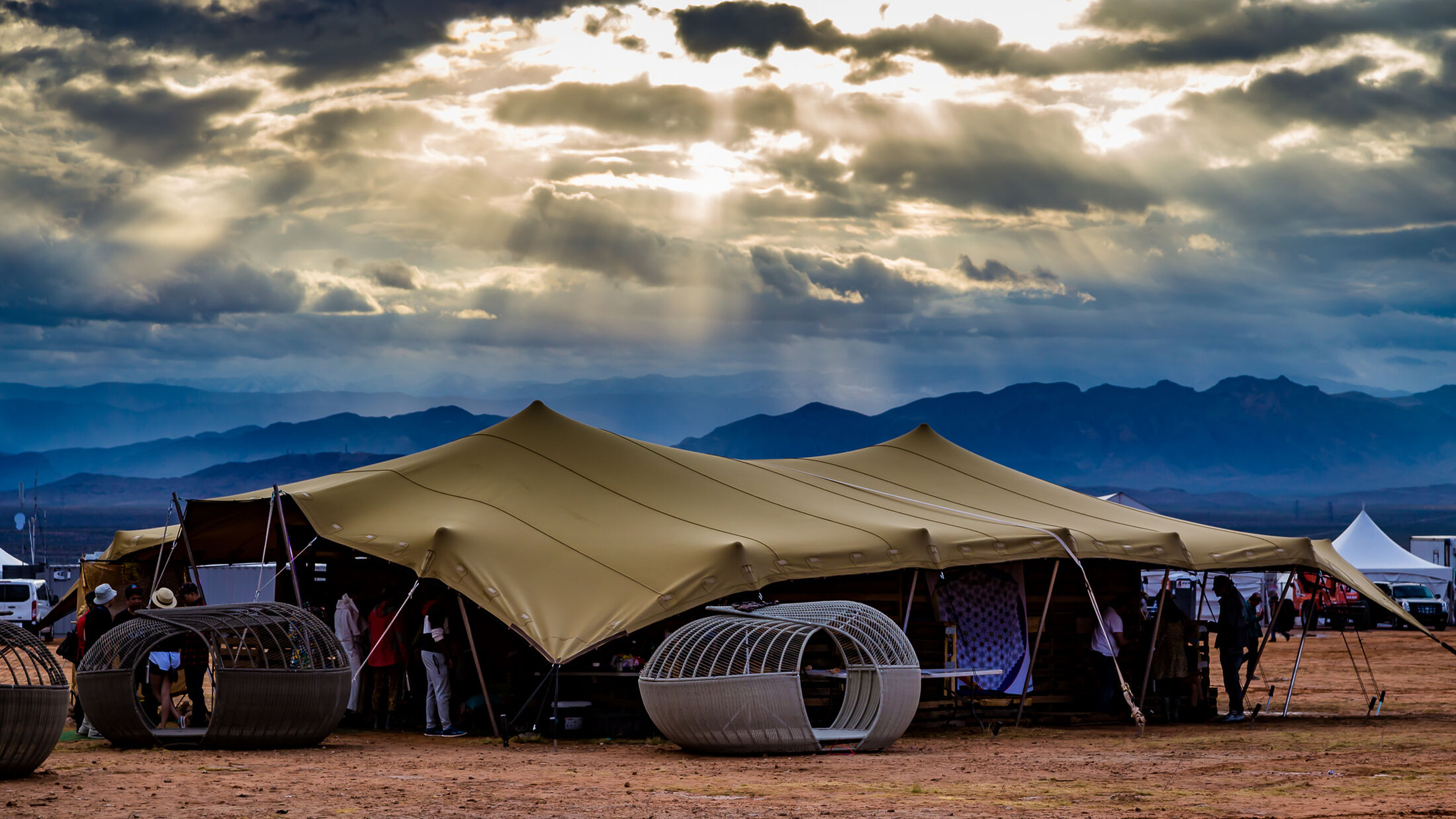 A chino stretch tent in the desert under a storm-lit sky