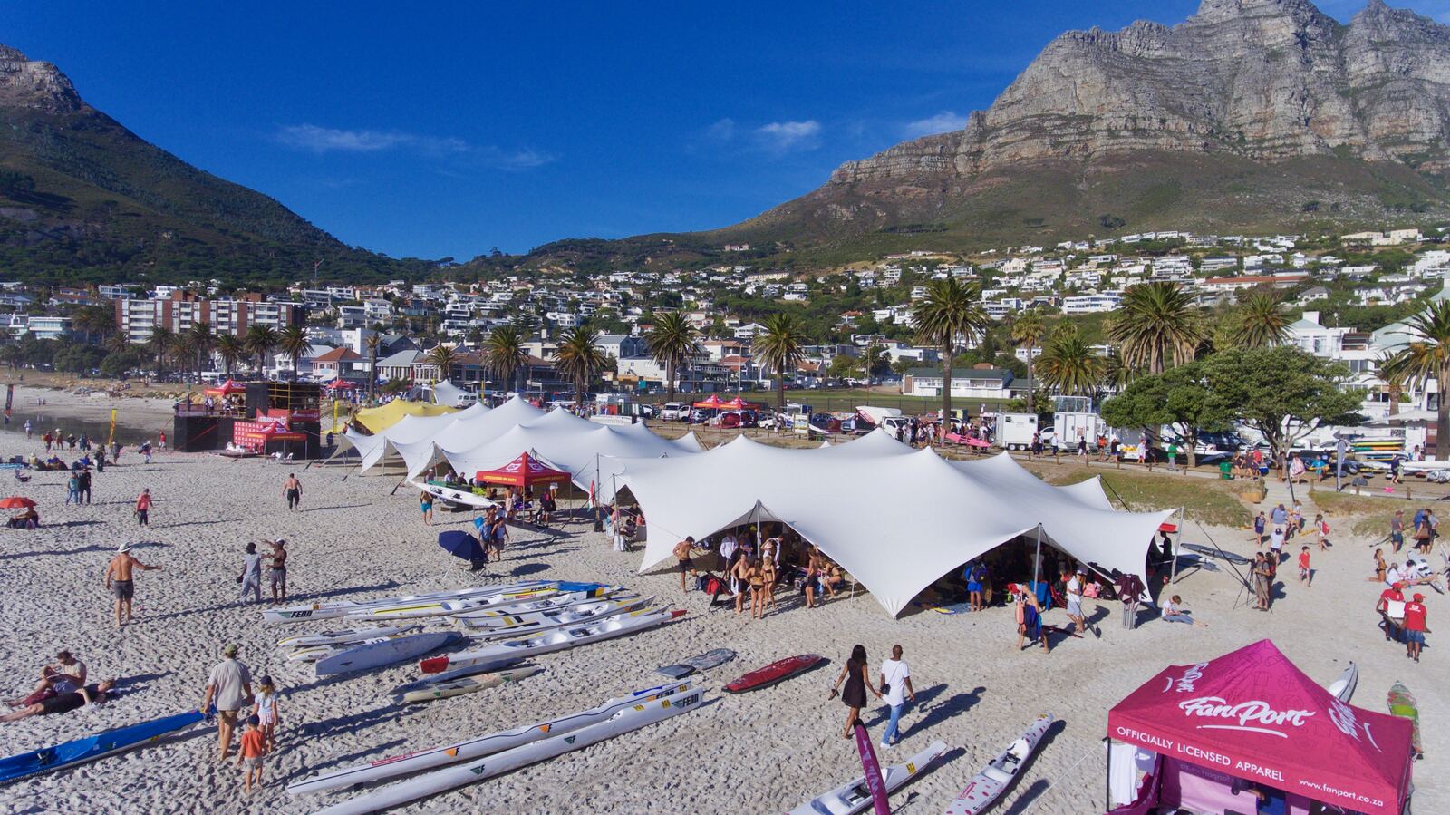 Aerial view of stretch tents on a beach below a mountain range