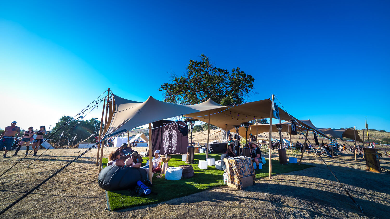 A lounge under a tan stretch tent