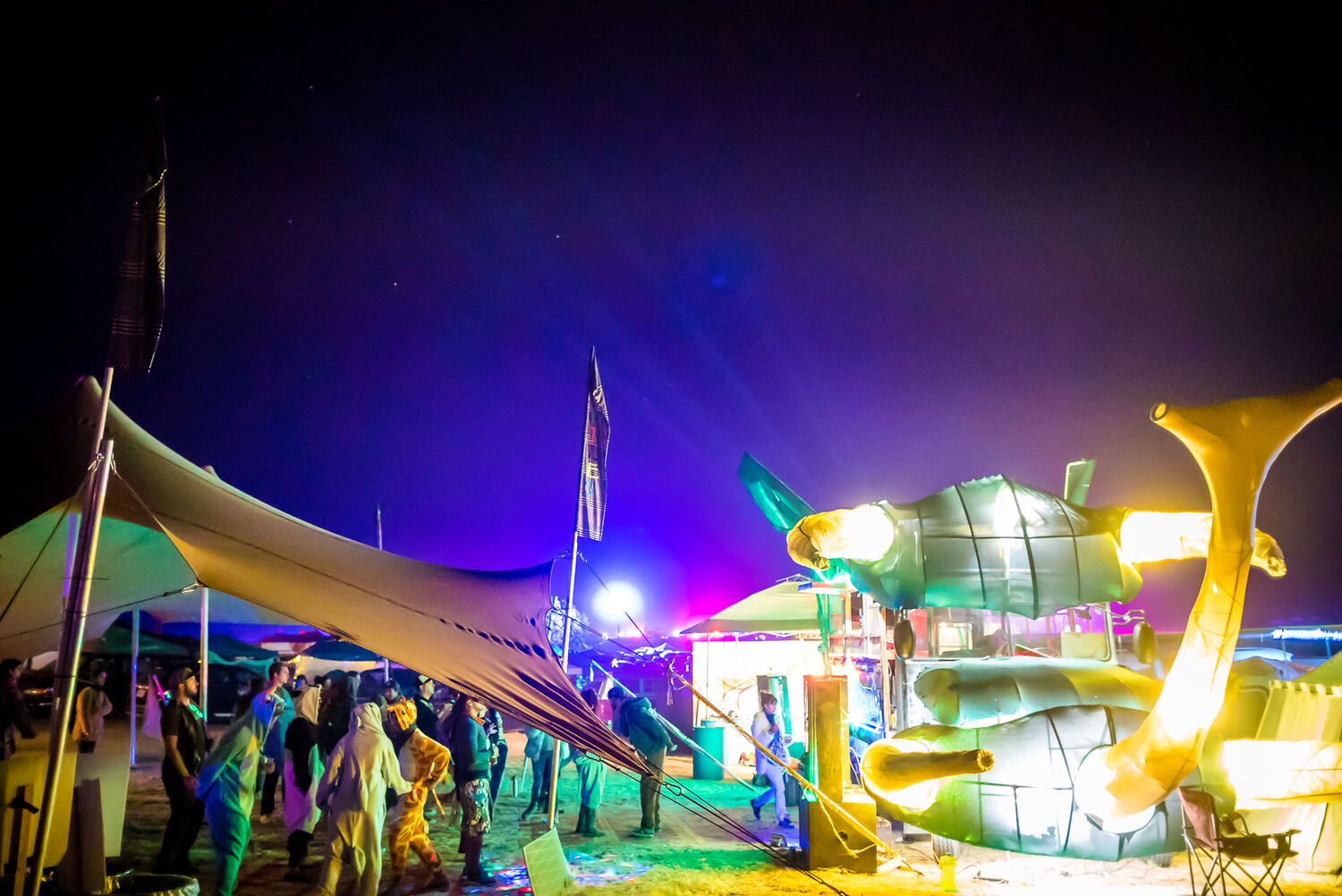 A stretch tent lit in colour at night